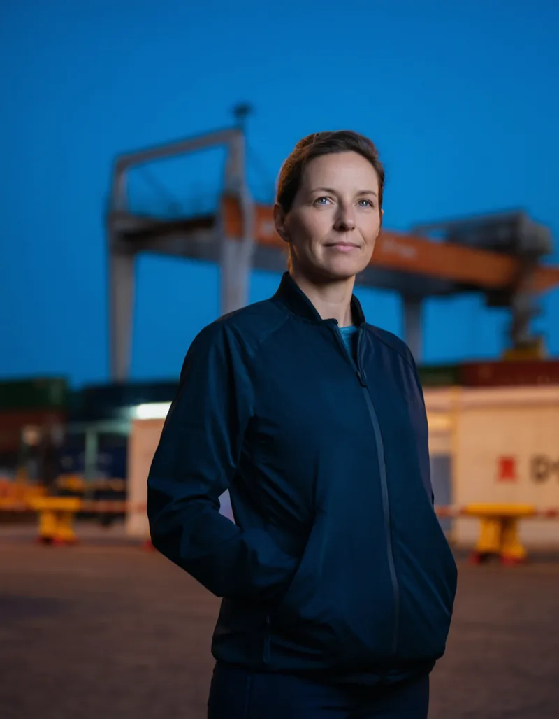 Dr. Annika Rehder standing on a container terminal quay at blue hour